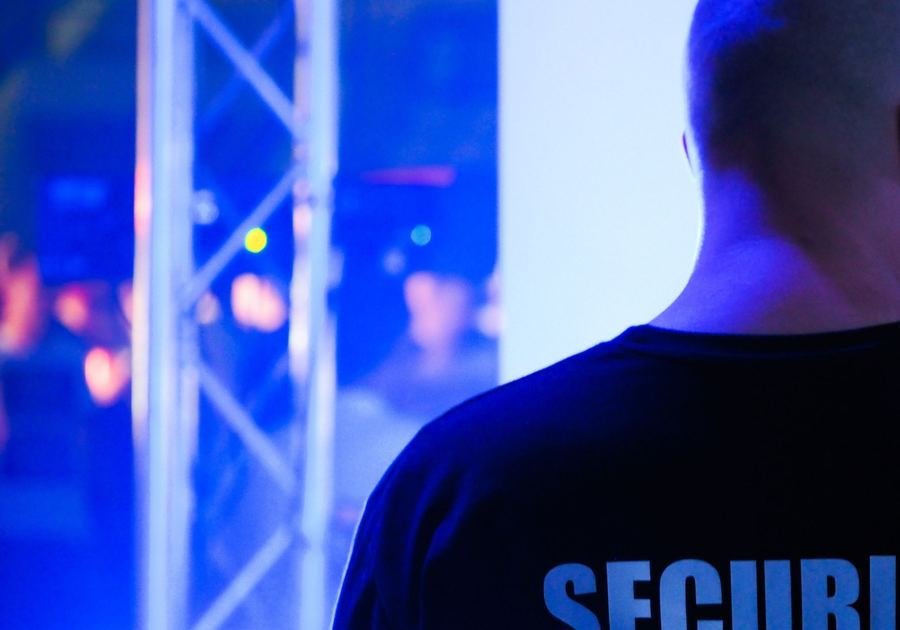 Door supervisor in a black security T-shirt at a venue